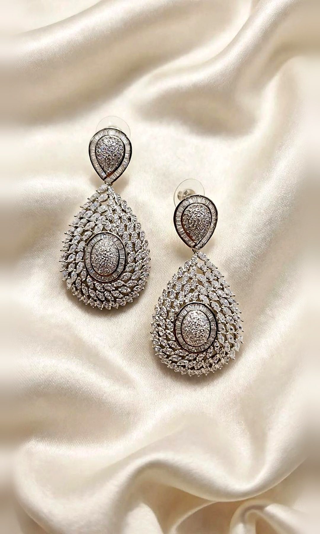 Silver Diamond-Look Teardrop Earrings — Silver-tone statement teardrops of marquise and pavé diamond-look stones around an oval centre, with a baguette-framed stud.