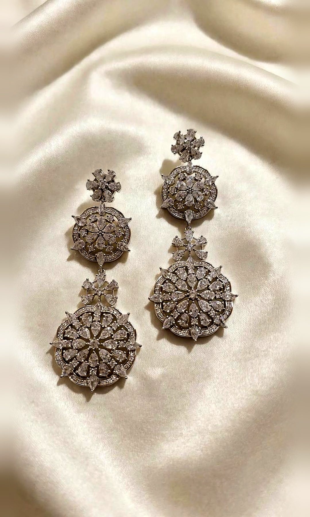 Silver Floral Double Drop Earrings — Long silver-tone earrings with two floral medallions of pear-cut diamond-look stones.