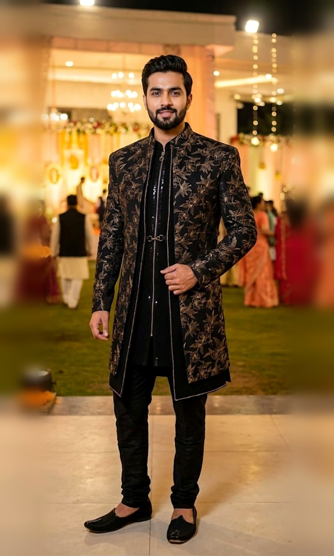Black & Gold Floral Indo-Western Sherwani — Black open-front indo-western sherwani with a gold floral pattern, piped edges and a sequinned inner kurta — shown with black churidar.